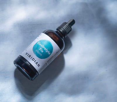 Bottle of Viridian Electrolyte Fix Liquid on a textured gray background