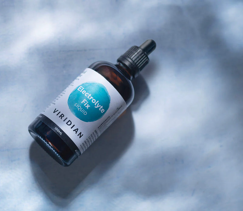 Bottle of Viridian Electrolyte Fix Liquid on a textured gray background
