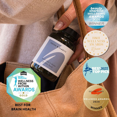 Bottle labeled 'Focus & Clarity' held by a hand, surrounded by various award badges on a beige background.