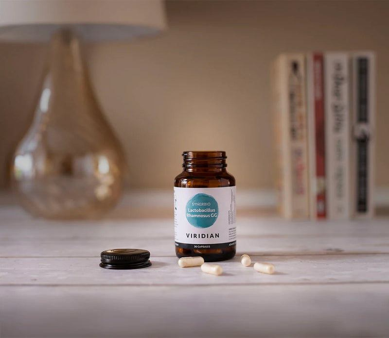 Bottle of Viridian supplements on a surface with books and a lamp in the background
