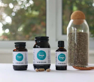 Three bottles of Viridian Sage on a white surface with a blurred natural background