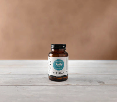 Viridian supplement bottle on a wooden surface with a brown background