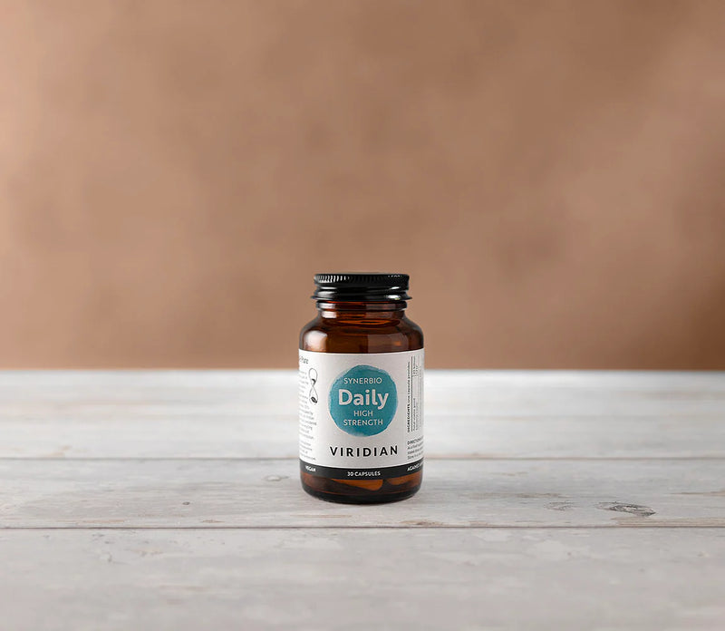 Viridian supplement bottle on a wooden surface with a brown background