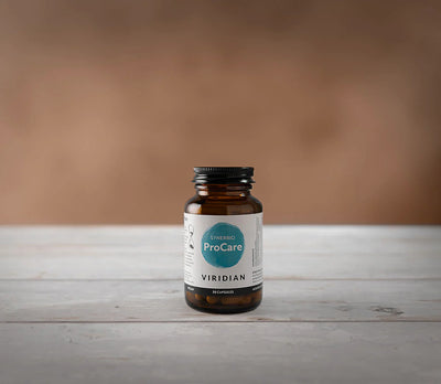 Brown supplement bottle with a label on a wooden surface and brown background