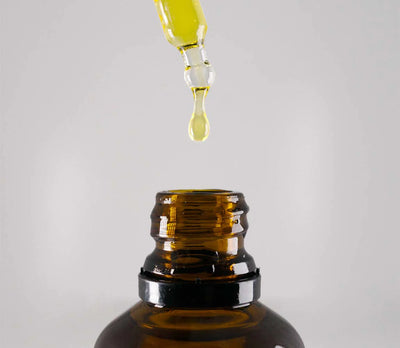 Brown glass bottle with dropper on a light gray background
