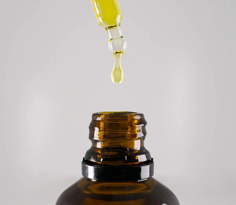 Brown glass bottle with dropper on a light gray background