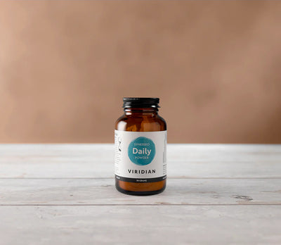 Amber bottle labeled 'Daily Powder' by Viridian on a wooden surface with a beige background