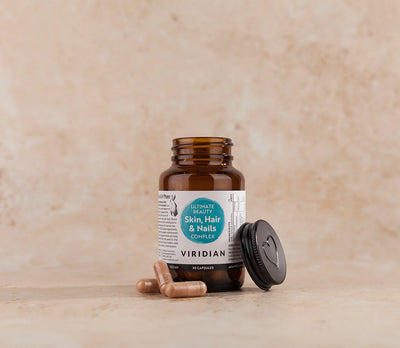 Brown supplement bottle with label on a beige background