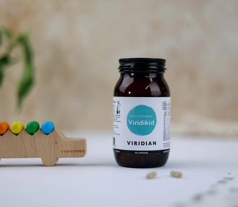 Viridian supplement bottle on a light surface with a blurred background