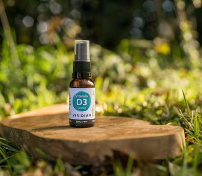 Vitamin D3 spray bottle on a wooden stump with a natural background